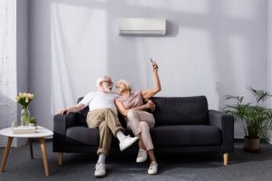 senior-couple-on-sofa-with-ductless-behind-them