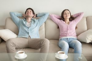 couple-relaxing-on-couch-with-smiling-faces-and-closed-eyes